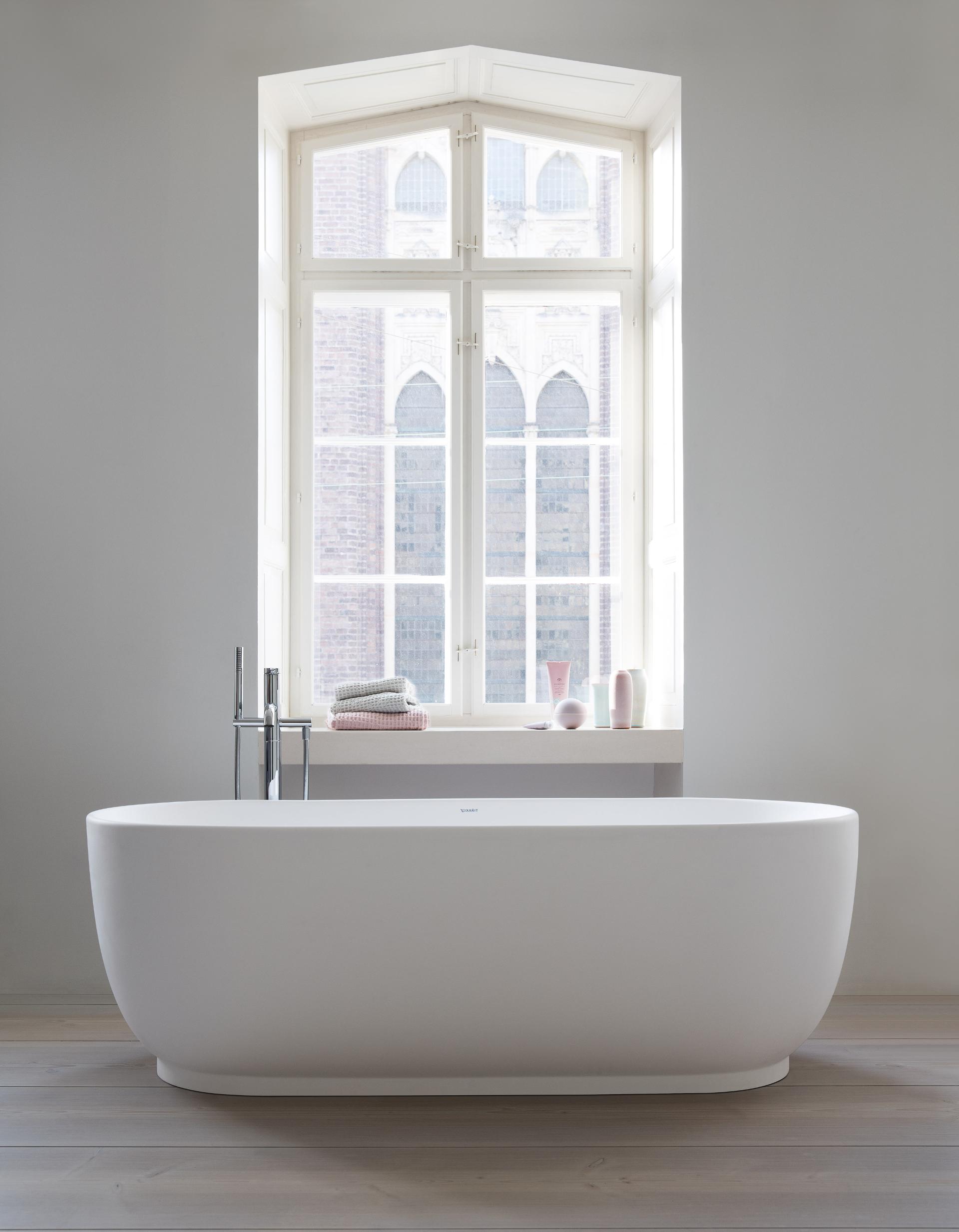 Freestanding Luv bathtub in front of a window
